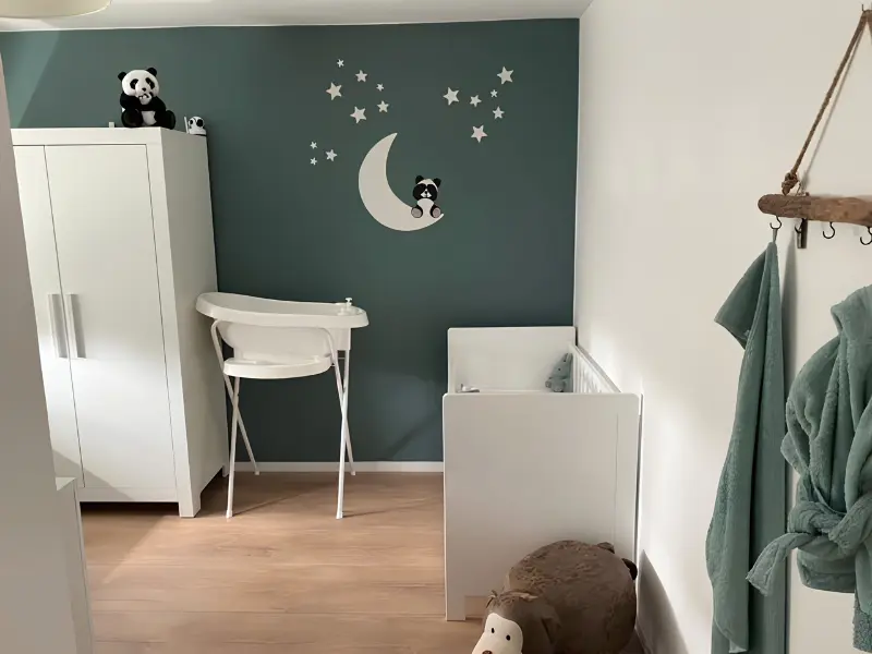 Groene babykamer met een panda beer op maan muurdecoratie